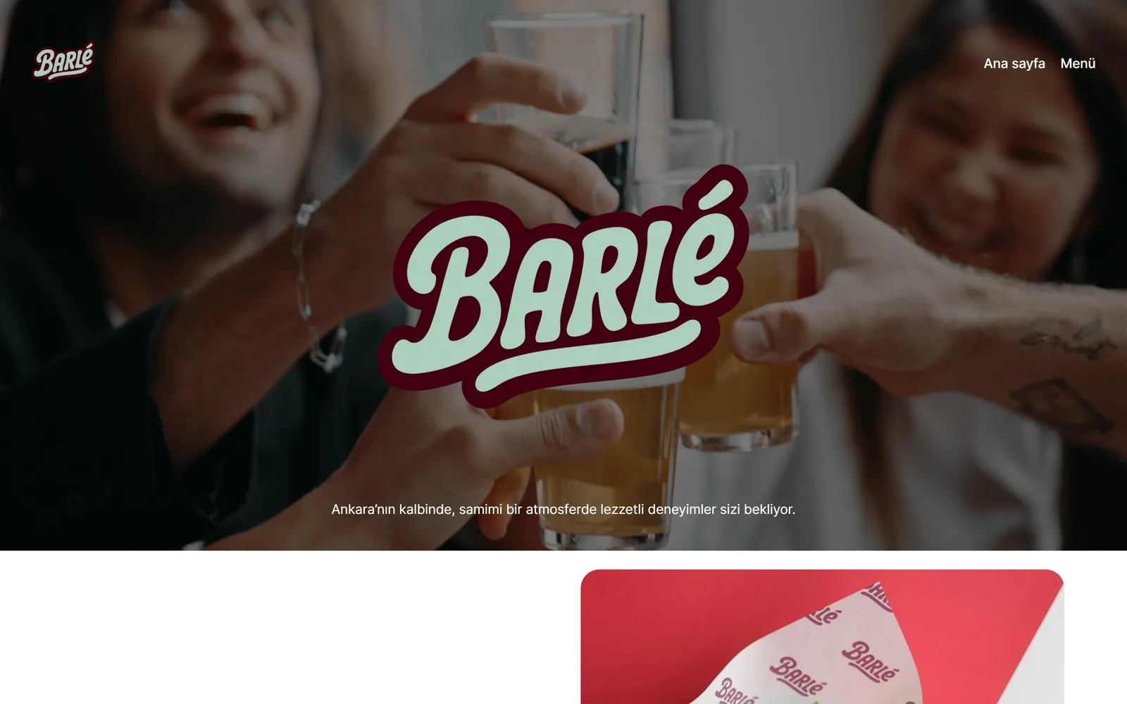 Pub tanıtım sitesinin açılış ekranı: bardakların tokuşturulduğu tam sayfa video üzerinde el yazısı logo ve tek satırlık tanıtım cümlesi, altında marka ambalajının yakın çekimi.