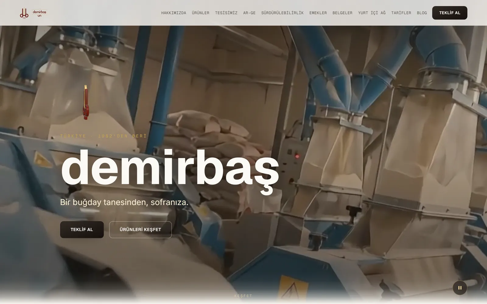 Un fabrikası kurumsal sitesinin açılış ekranı: fabrika içi değirmen hattının videosu üzerinde marka adı, tanıtım cümlesi ve teklif al butonu; üstte tesis, ar-ge ve belgeler başlıklarını içeren menü.